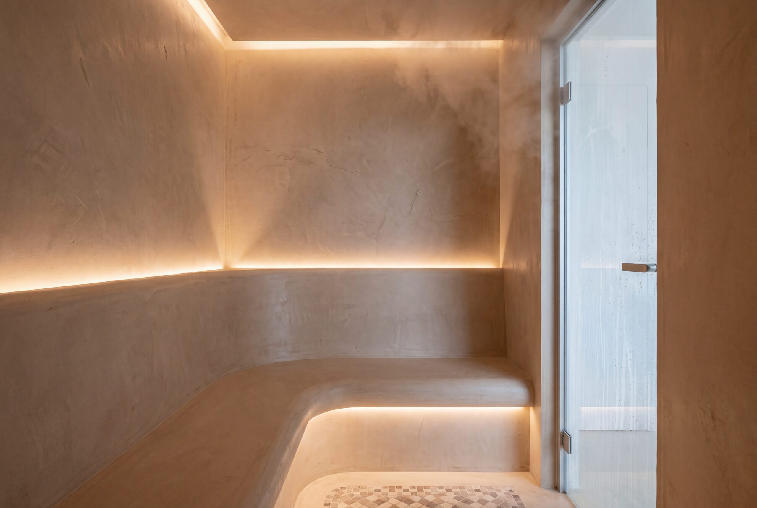 Hammam domestico su misura con rivestimento in microcemento e seduta in muratura