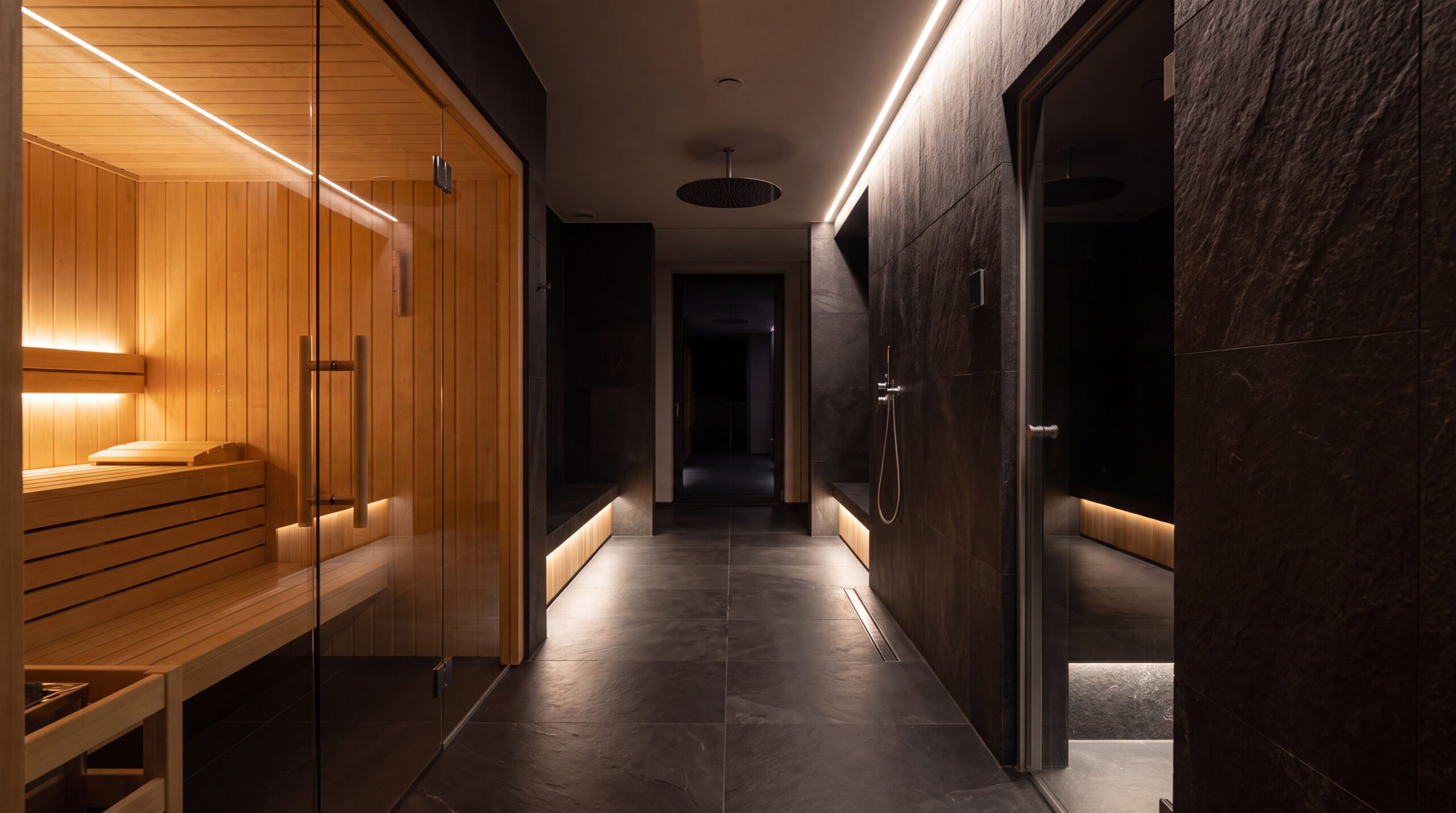 Area wellness domestica con sauna, bagno turco e doccia emozionale integrati in un unico percorso